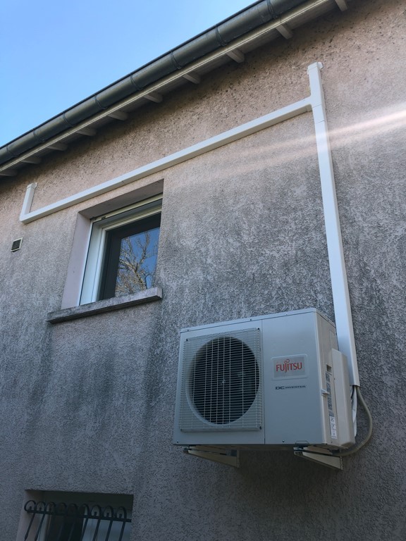 bloc extérieur système de climatisation fujitsu atlantic accroché à la façade d'une maison